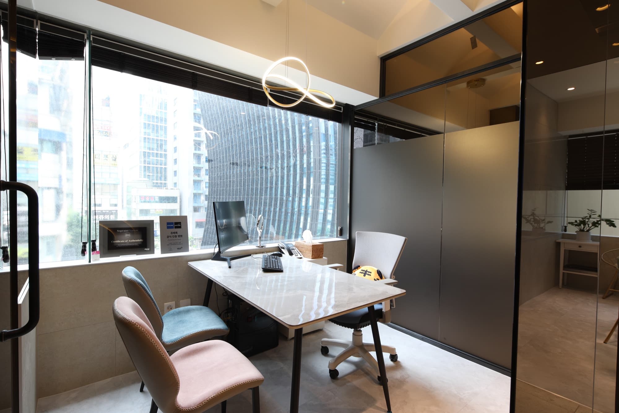One-on-one consultation suite framed by a sculptural ring light and full-height windows over the city