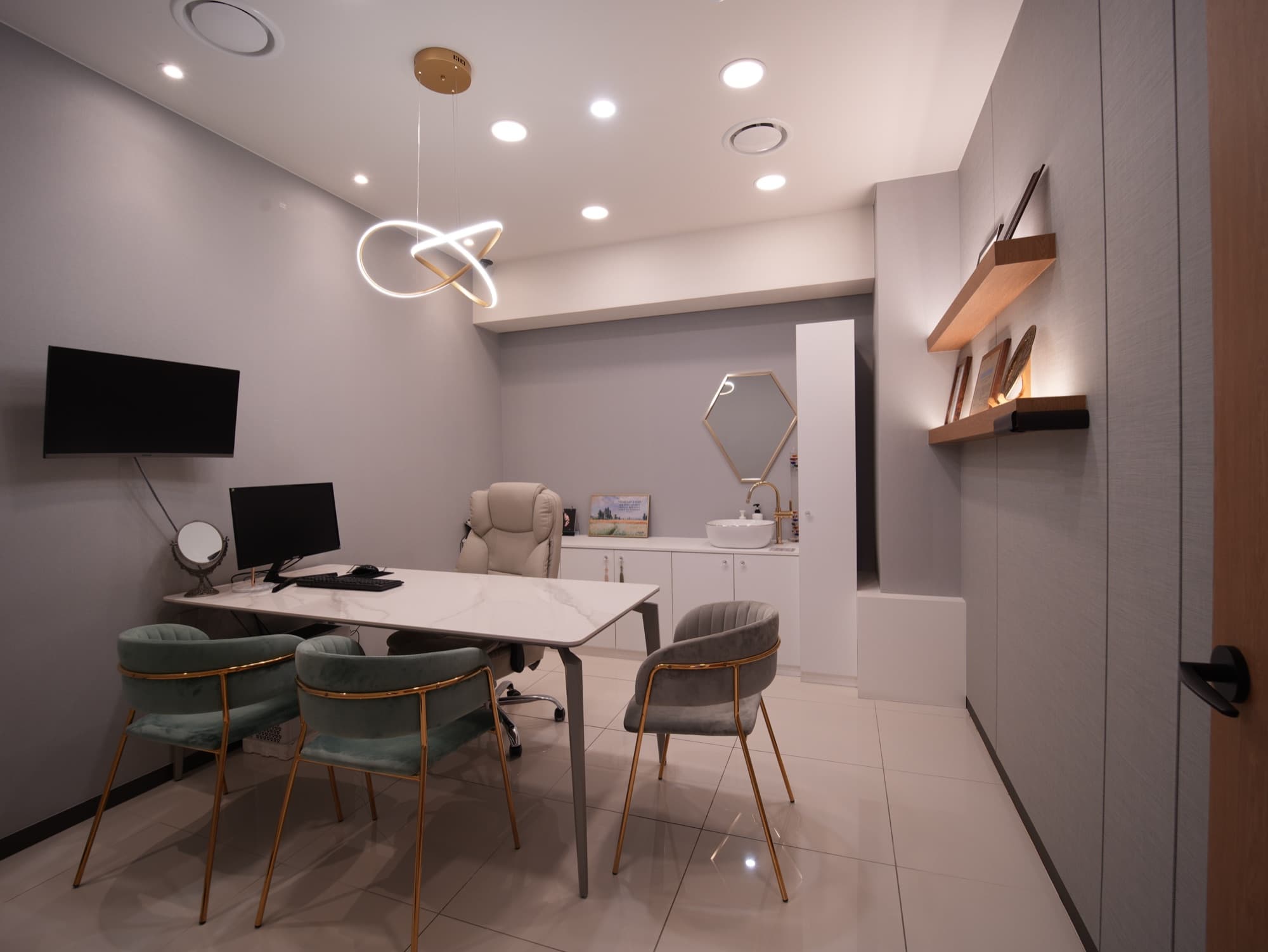 Modern counseling room with a marble table, mint velvet chairs and a hexagonal vanity mirror