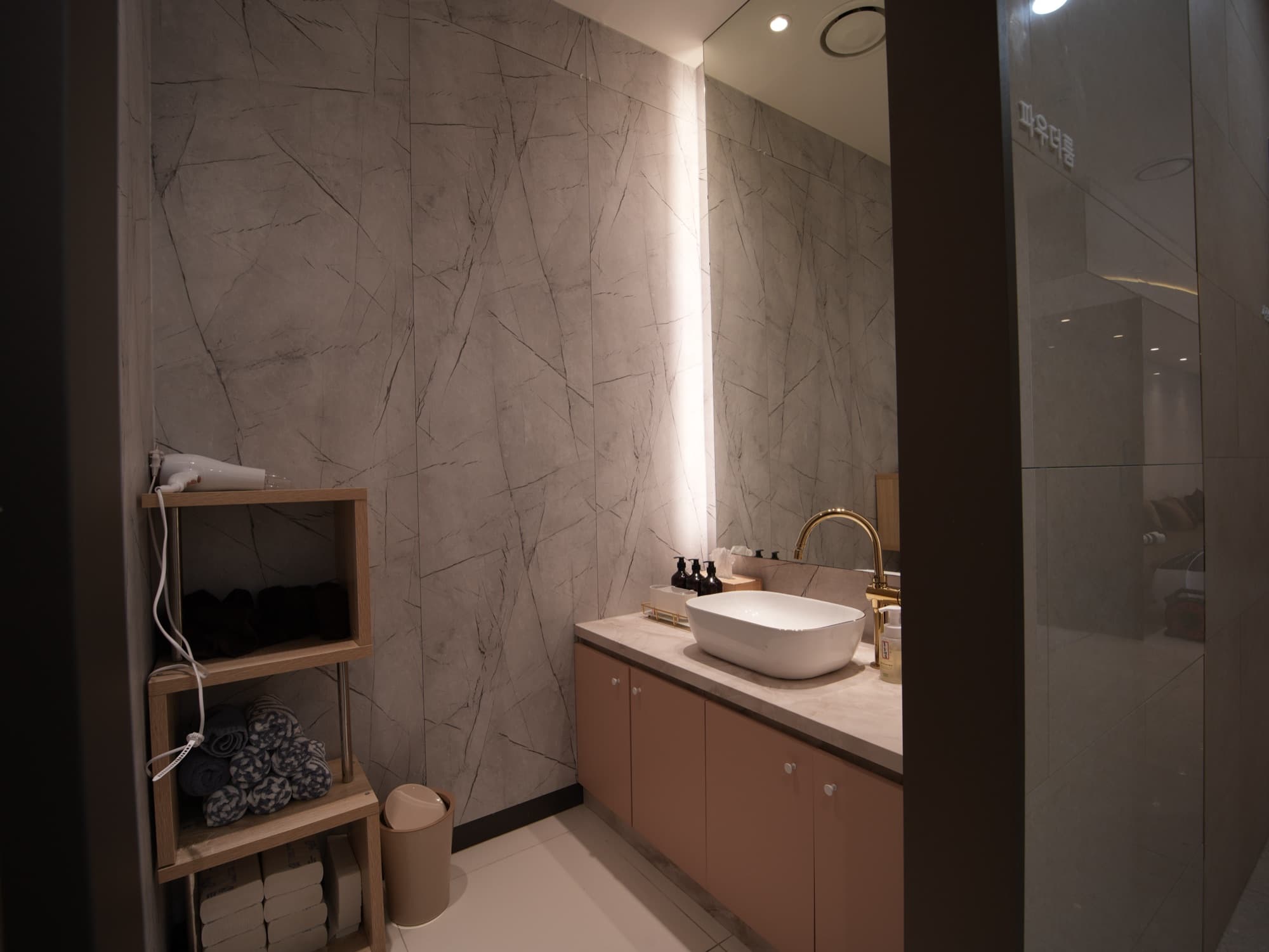 Marble powder lounge stocked with towels, hair dryer and premium amenities for patient comfort