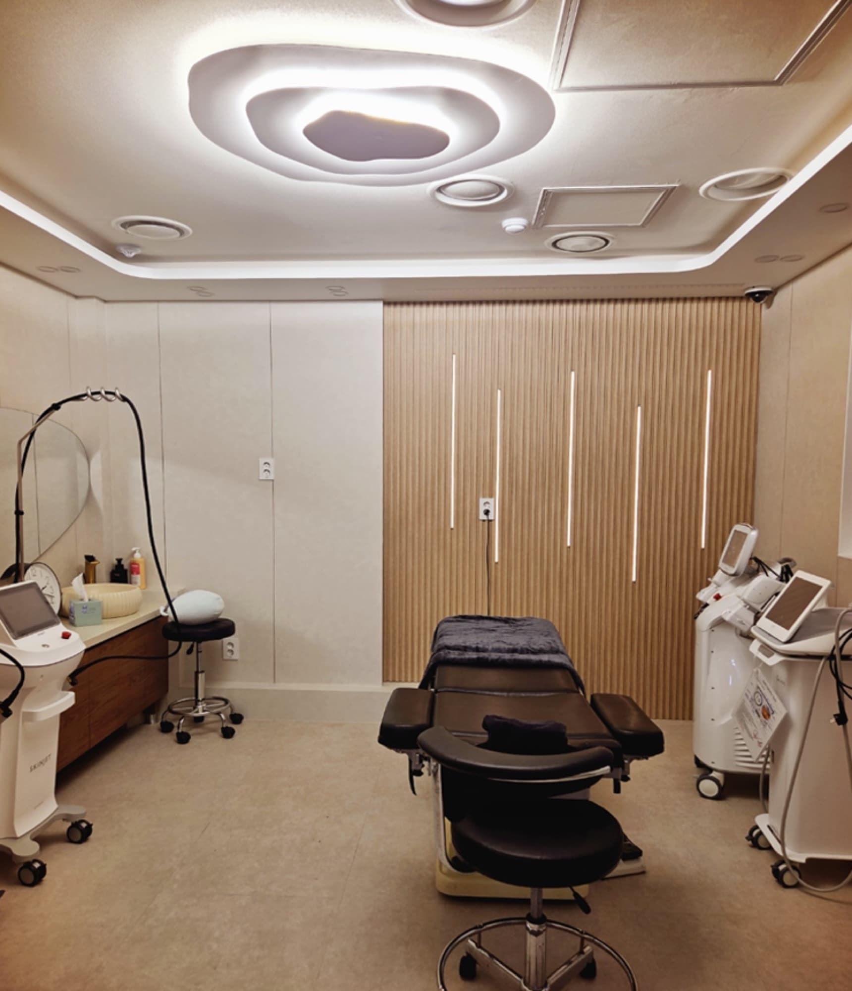 Private VIP treatment suite with warm wood-slat walls, mood ceiling lighting and dedicated device stations